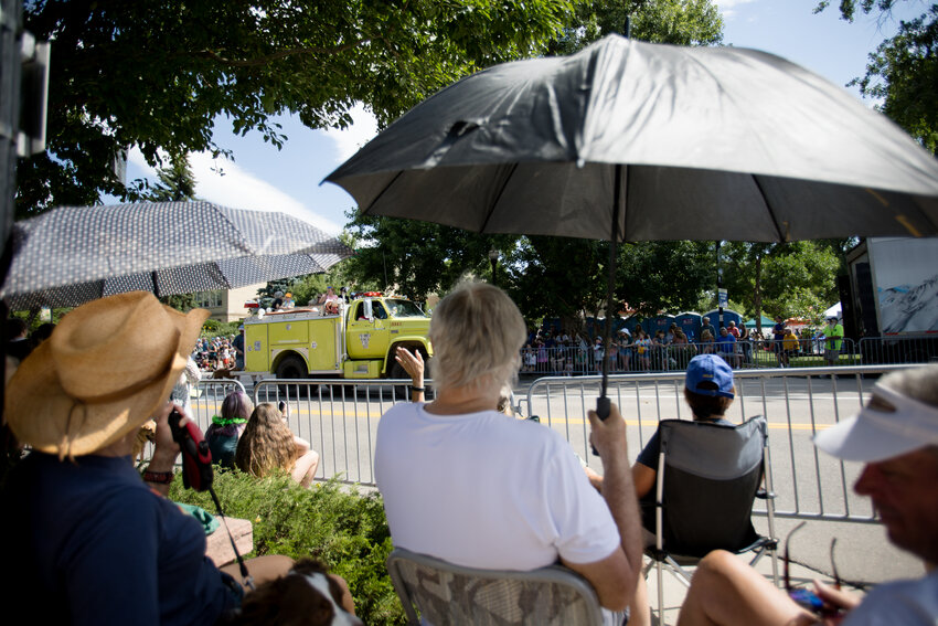 Spectators use umbrellas to shade themselves from the morning sun during the Buffalo Bill Days parade.